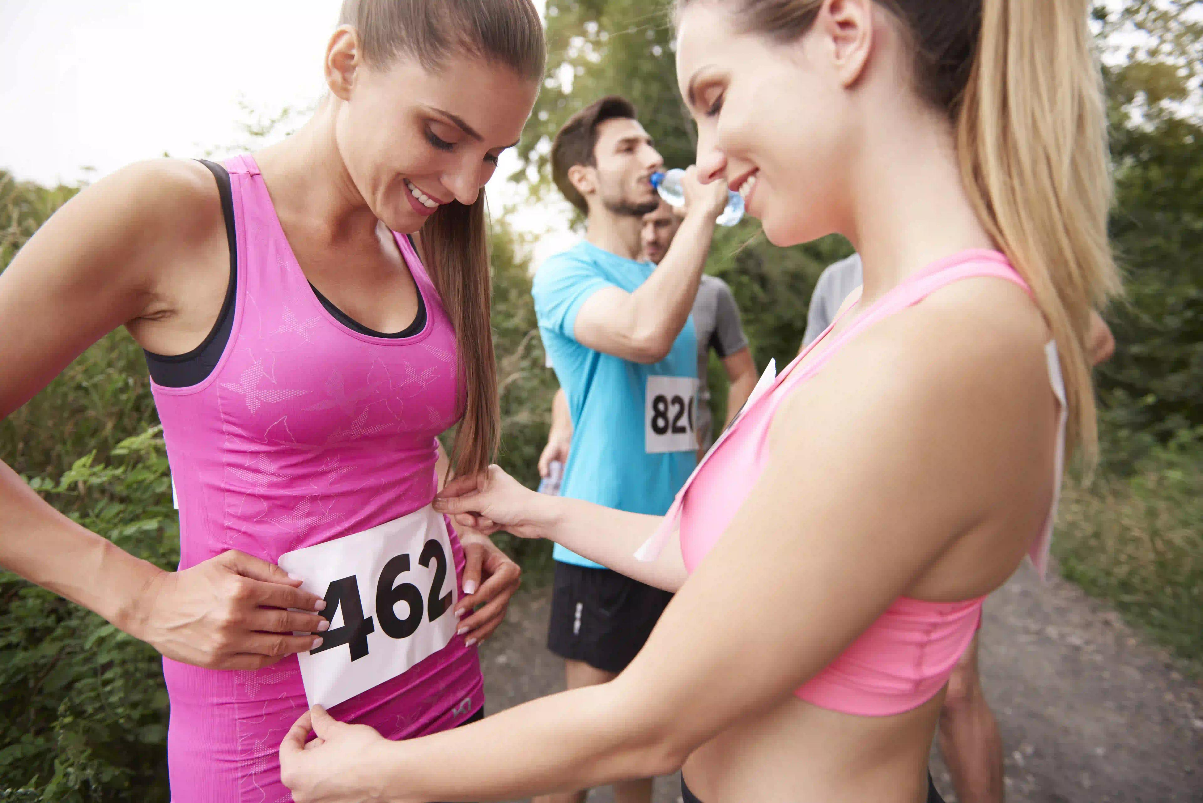 Chicas colocándose el número de participante en la camiseta